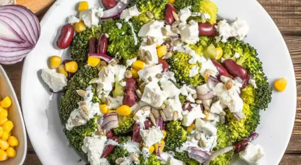 Ensalada de brócoli con frijoles rojos, maíz, queso feta y semillas de girasol. Un ejemplo de dieta saludable.