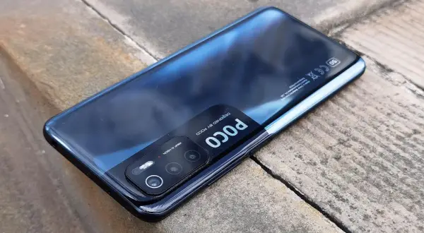Czarny Xiaomi Poco M3 Pro z modułem aparatów 48MP AI VISION, leżący na kamiennym podłożu.