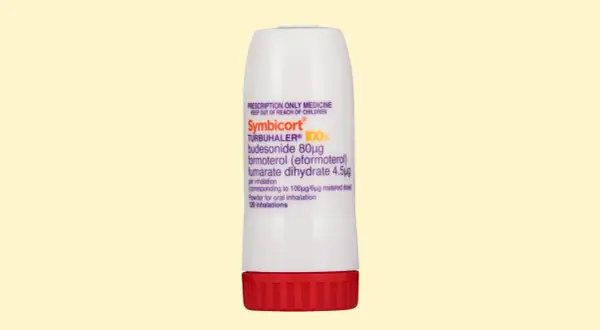 Biały inhalator Symbicort Turbuhaler z czerwonym wieczkiem, zawierający proszek do inhalacji.