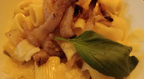 Makaron z chrupiącym guanciale, parmezanem i listkiem bazylii. To właśnie guanciale nadaje daniu wyjątkowy smak.