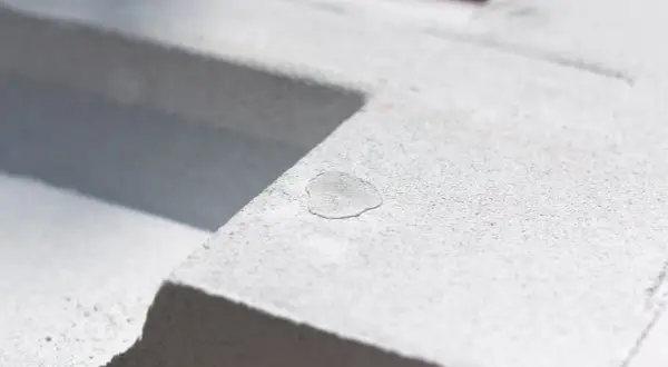 Kropla wody na porowatej powierzchni bloczków z perlitu. Materiał budowlany w zbliżeniu.