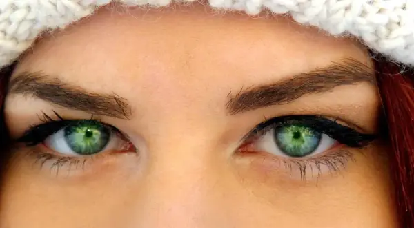 Oczy z zieloną tęczówką, podkreślone eyelinerem i tuszem, idealne dla tych, które szukają odpowiedzi na pytanie: jakie rzęsy do opadającej powieki.