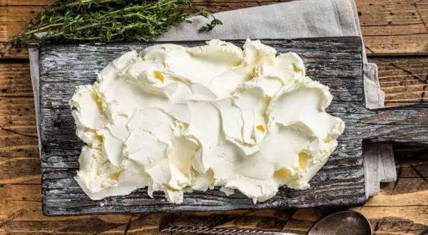 Kremowe mascarpone na desce. Zastanawiasz się, czy mascarpone można mrozić? Ten ser jest idealny do deserów, ale mrożenie może zmienić jego konsystencję.