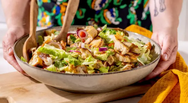 En stor skål med en härlig sallad med krispig sallad, grillad kyckling och krutonger. Perfekt för sommarmat recept!