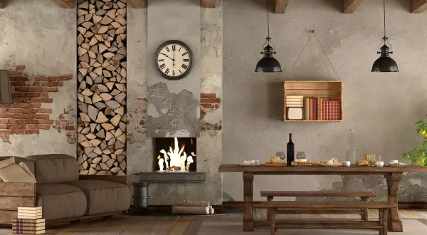 Un soggiorno rustico con camino acceso, divano, tavolo in legno e scaffale con libri. Stili di arredamento che evocano calore e tradizione.