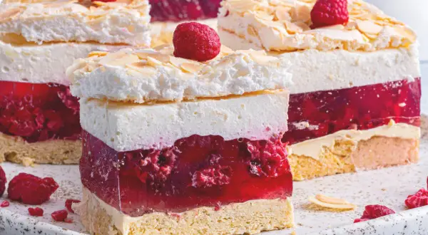 Malinowa chmurka z bezą i malinami. Ile piec bezę do malinowej chmurki? Warstwy biszkoptu, galaretki z malinami, kremu i bezy ze płatkami migdałów.