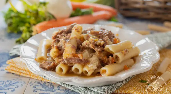 Piatto di ziti alla genovese con ragù di carne sfilacciata e verdure. Un classico della cucina napoletana.