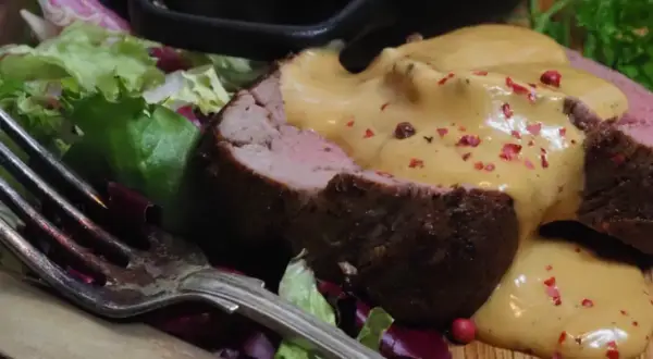 Saftig oxfilé med en krämig sås, garnerad med rosa pepparkorn och serverad med en fräsch sallad. En perfekt sås till oxfilé!