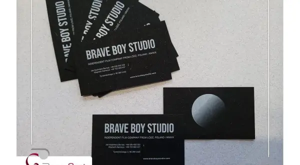 Wizytówki "Brave Boy Studio" z białym napisem na czarnej kartce. Pokazują, jak wydrukować biały napis na czarnej kartce, tworząc elegancki efekt.