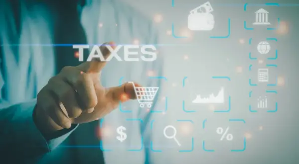 Dłoń dotyka ekranu z napisem TAXES. Wokół ikony symbolizujące finanse, handel i analizę danych, jak koszyk, portfel, wykresy, lupa, procent, kalkulator, bank i globus. To cyfrowy świat zarządzania podatkami, gdzie każdy element ma swoje znaczenie w sys...