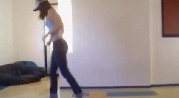 Ragazza con cappellino e jeans che si muove a ritmo, mostrando come si balla la techno con passi energici.