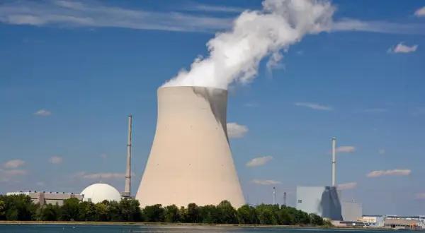 Chłodnia kominowa i budynki elektrowni atomowych w Niemczech na tle błękitnego nieba.