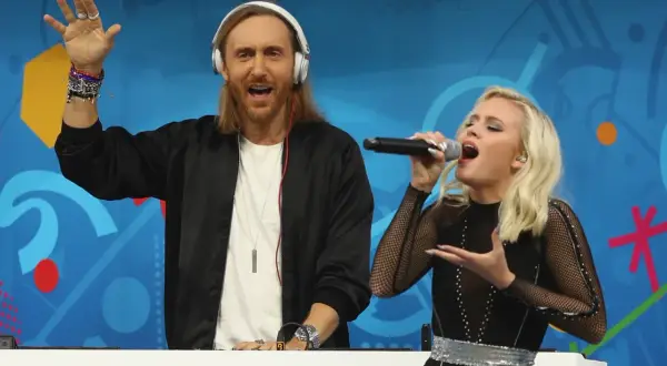 David Guetta Polska: DJ z mikrofonem i wokalistka na scenie, bawią publiczność.