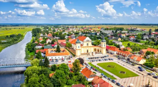 Malowniczy widok na Tykocin z rzeką, mostem i barokową bazyliką. Odkryj **Tykocin atrakcje** i poczuj klimat tego miejsca.