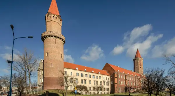 Zamek Piastowski w Legnicy, jedna z głównych atrakcji miasta, z charakterystyczną wieżą i czerwonym dachem.