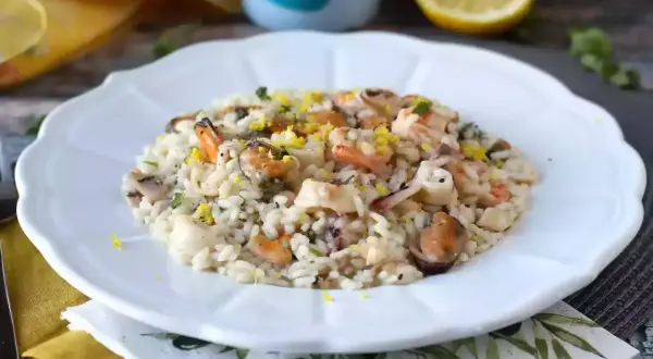 Un délicieux risotto fruits de mer crémeux, garni de zestes de citron et de persil frais.