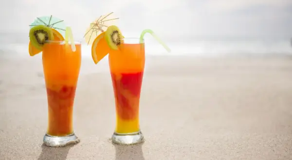 Dwa drinki na plaży, idealne na malibu sunrise. Orzeźwiające kolory i tropikalne owoce.