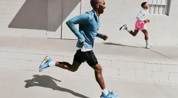 Due corridori si allenano per la maratona. Uno con capelli viola, l'altro con pantaloncini rosa. La loro velocità media maratona 42 km è impressionante.