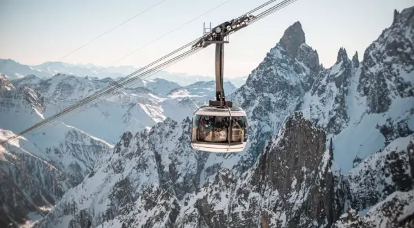 Cabina della funivia sorvola montagne innevate, un'esperienza imperdibile per scoprire Courmayeur cosa vedere.