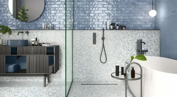 Salle de bain moderne avec carrelage mural bleu brillant et sol terrazzo. La taille du carrelage mural salle de bain est rectangulaire, créant un effet de profondeur.