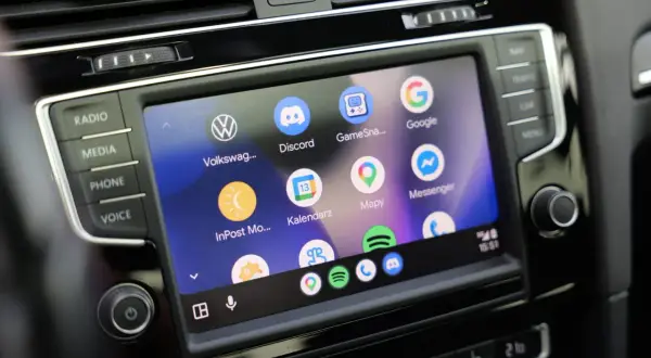 Ekran samochodu z ikonami aplikacji: Volkswagen, Discord, Mapy, Google, Messenger. Widoczne są też przyciski Radio, Media, Phone, Voice. To są android auto ustawienia.