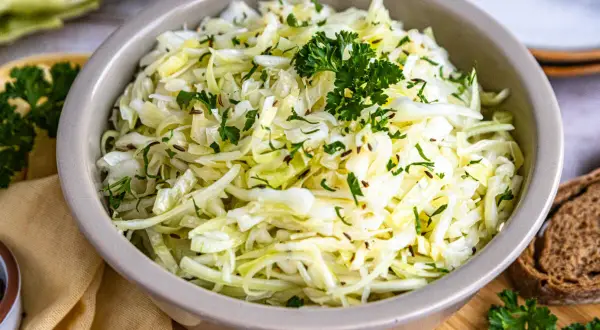 Frischer spitzkohl salat mit Kümmel und Petersilie, garniert mit einem Petersilienzweig.