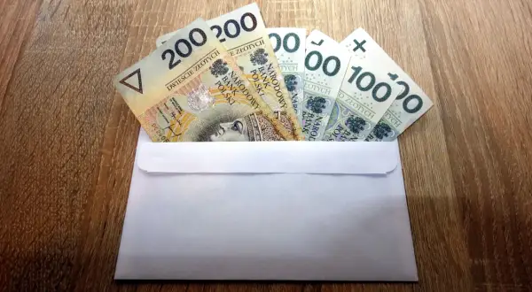 Koperta z banknotami 200 i 100 zł. Ile dać na 40 urodziny w lokalu?