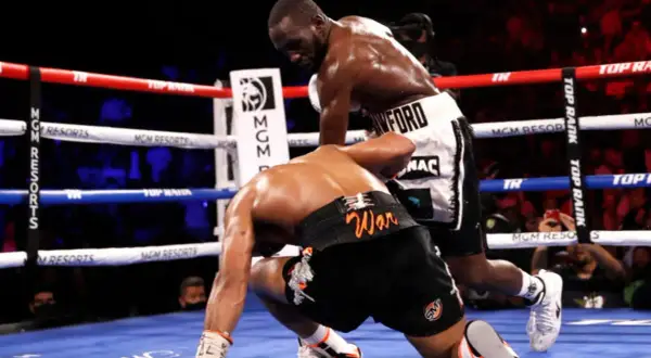 Terence Crawford, a southpaw, lands a powerful punch, sending his opponent to the canvas.