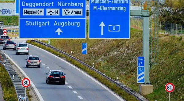Autostrady w Niemczech: znaki kierunkowe do Salzburga, Norymbergi, Stuttgartu, Augsburgu i centrum Monachium. Ruch samochodowy.