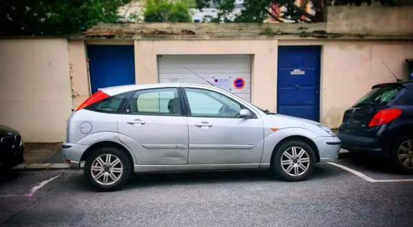 Une voiture argentée est garée devant un garage. Une autre voiture est garée juste derrière. Peut-on se garer devant son garage ?