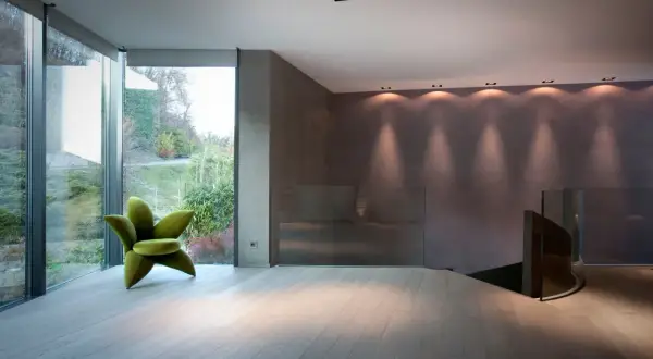 Pavimenti in legno chiaro, ideali come materiali per pavimenti in un ambiente moderno con poltrona verde a forma di fiore.