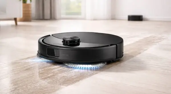 Un robot aspirador negro con luces azules limpia un suelo de madera. Así es como funciona un robot aspirador.