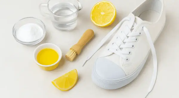 Tutto l'occorrente per scoprire come lavare le Converse bianche: bicarbonato, limone, acqua, spazzolino e una scarpa.