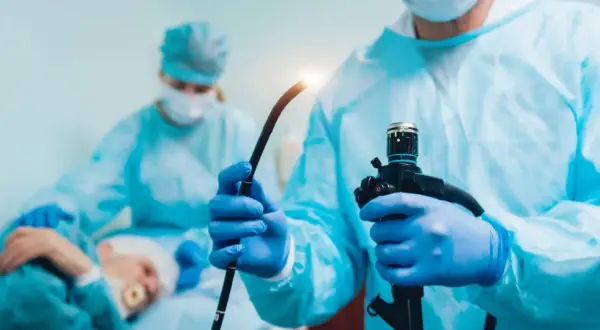Lekarz w rękawiczkach przygotowuje endoskop do gastroskopii i kolonoskopii za jednym razem NFZ.