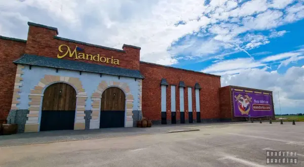 Mandoria, gdzie jest? To park rozrywki w stylu średniowiecznym, z ceglanymi murami i wielkimi bramami.