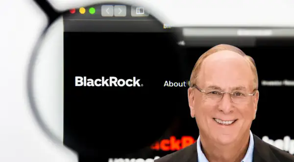 Larry Fink, CEO BlackRock, zarządza ogromnymi aktywami. Na ekranie logo firmy i hasło "About us".