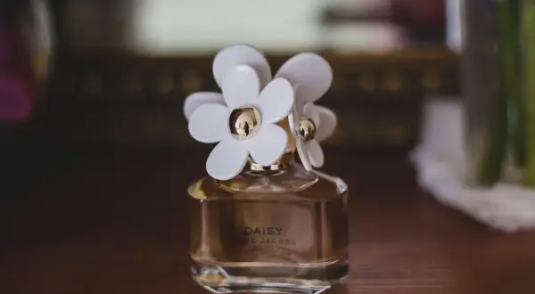 Flakonik perfum Daisy Marc Jacobs z białymi kwiatkami. Czy perfumy mają datę ważności? Ten zapach wciąż zachwyca.