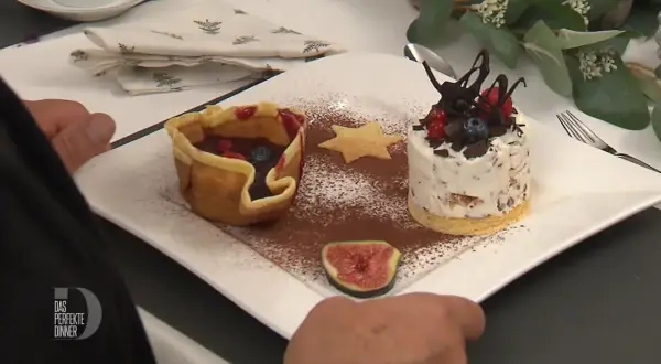 Omas eistorte: eine zarte Eistorte mit Schokostückchen, Beeren und einem Keksstern, daneben ein Körbchen mit Früchten.
