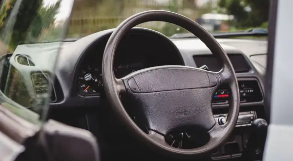 Wnętrze Suzuki X90: kierownica, deska rozdzielcza z zegarami i radiem, widok z perspektywy kierowcy.
