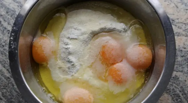 Rohe Eier und Mehl in einer Schüssel. Manche Leute essen Mehl roh, aber das ist nicht empfehlenswert.
