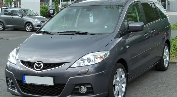 Szary minivan Mazda 5 na parkingu. Wiele osób szuka mazda 5 opinie, ten model jest dobrym wyborem.