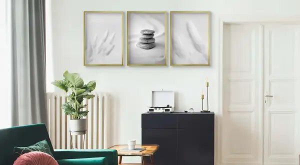 Minimalistyczne plakaty z piórami i kamieniami, zawieszone na ścianie. Idealne do salonu, gdy zastanawiasz się, czym przykleić plakat do ściany.