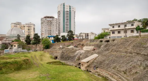 Ruiny amfiteatru w Durres, Albania, kontrastują z nowoczesnymi budynkami w tle.