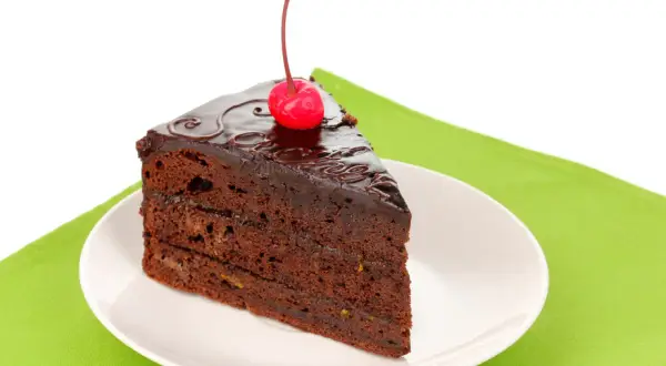 Pyszny kawałek tortu czekoladowego z wiśnią na wierzchu. Zastanawiasz się, ile kalorii ma taki kawałek tortu czekoladowego?