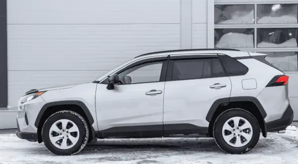 Srebrny crossover stoi na śniegu. To idealny samochód na zimowe wyprawy, bo to właśnie crossover co to za auto, które łączy cechy SUV-a i kombi.