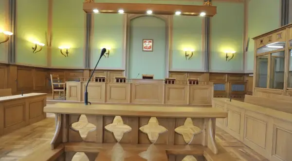 Pusta sala rozpraw. Sędzia siedzi za stołem, po bokach ławy dla ławników i prokuratora.