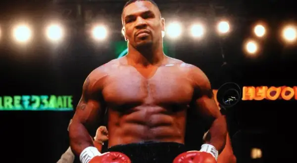 Mike Tyson's incredible build is on full display in the boxing ring, with red gloves ready.