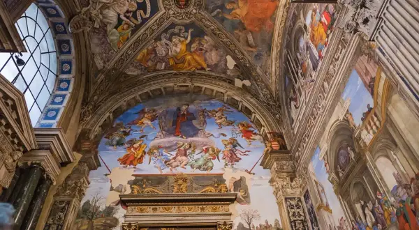 Affreschi mozzafiato adornano le volte di una delle chiese da vedere a Roma, un tripudio di angeli e figure bibliche.