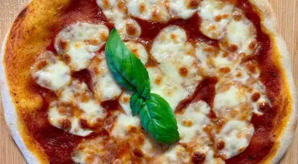 Eine köstliche italienische Sauerteig Pizza Margherita mit geschmolzenem Mozzarella und frischem Basilikum.