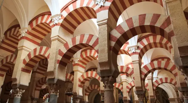 Las icónicas partes de la mezquita de Córdoba: arcos de herradura bicolores y columnas que crean un laberinto arquitectónico.